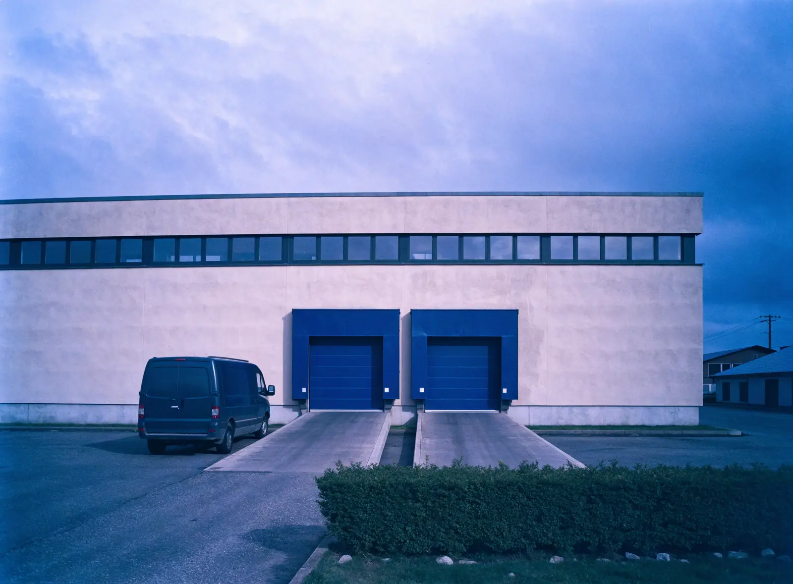 KI-Entwurf: Gewerbebau mit Laderampe — Stellvertretermotiv, nicht das Gebäude in der Fabrikstraße.